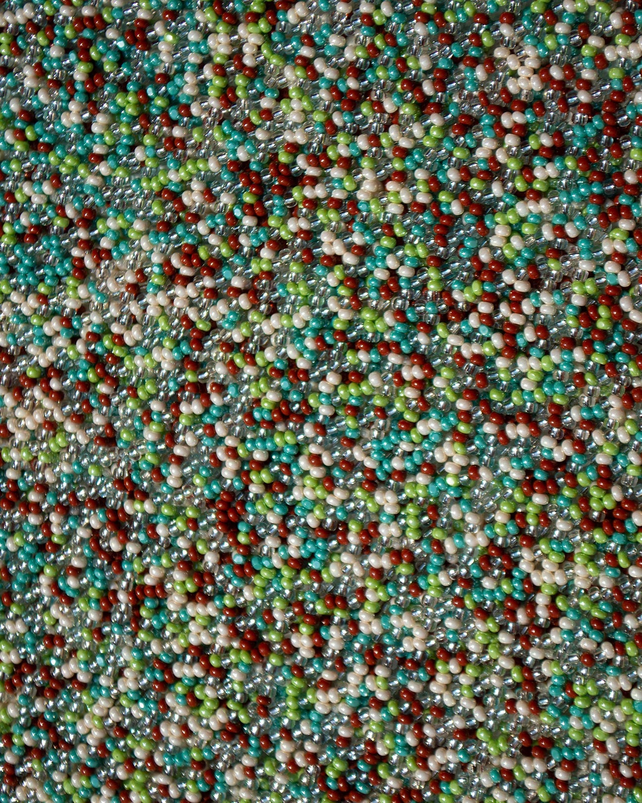 closeup picture of the beads as they are in all Marmaclub Fringe Earth Mix bags, a mix of beige,brown,green colors
